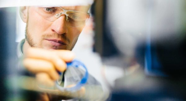 Man in safety glasses inspecting product