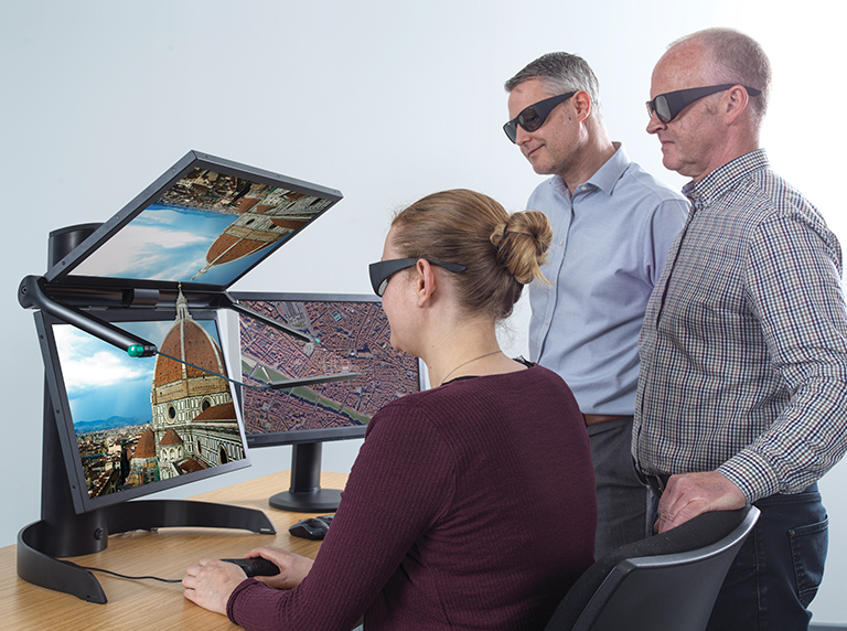 Lady wearing 3D glasses looking through VECTOUR 2 men standing also wearing 3D glasses